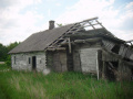 Zdjęcie maleńkiej wróżki przelatującej obok ruiny chaty