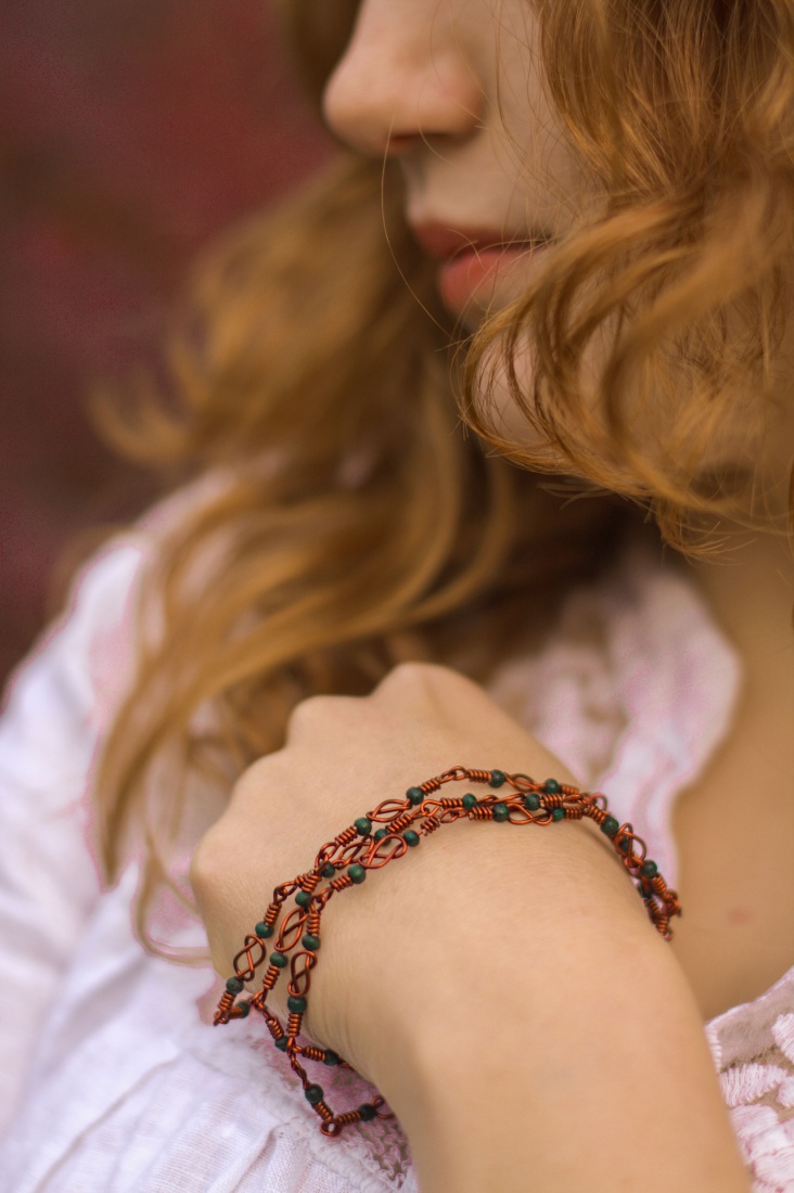 Miedziany naszyjnik na celtycką modłę, drewniane barwione koraliki. Modelka: Kasia.